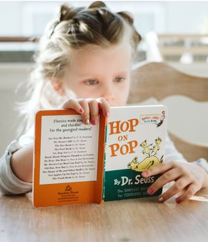 A little girl reading Dr. Seuss